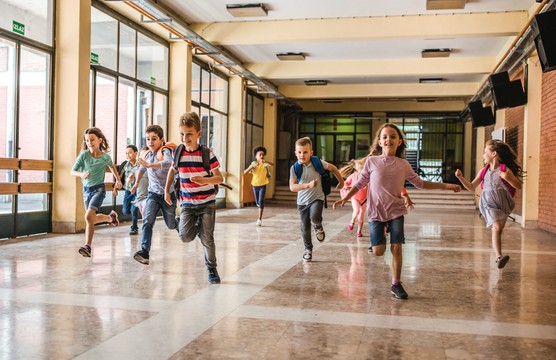 dzieci biegną po szkole
